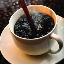 Cup of brewed black coffee with a stream pouring in