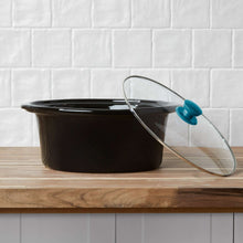 Black stoneware insert and glass lid on oval slow cooker with teal knob