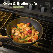 Black nonstick skillet in an oven, holding roasted vegetables and chicken