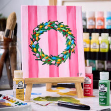 Painting wreath project on easel with acrylic paints and a paintbrush