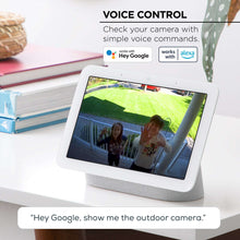 White outdoor security camera with voice control, shown with smart home assistant display