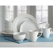 White stoneware dinnerware set with lace-pattern plates, bowls, and coffee mugs