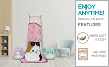 Plush blanket hanging with pink rainbow stripes and smiling animal faces print
