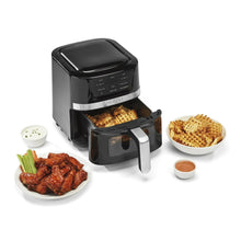 Black digital basket air fryer with open basket and silver handle, with plates of food