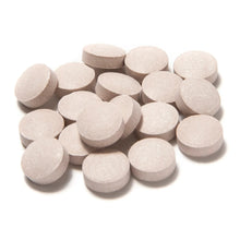 Chewable aspirin tablets, round light tan tablets in a pile