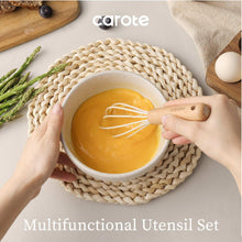 White silicone whisk with light wood handle whisking yellow batter in a bowl