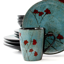 Blue dinnerware plates and mugs with red floral pattern and black interiors