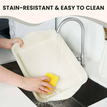 Beige nonstick baking pan being wiped clean with sponge
