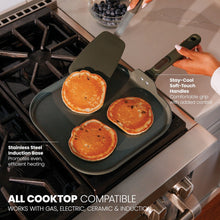 Moss green nonstick griddle pan on gas stove, pancakes flipped with spatula
