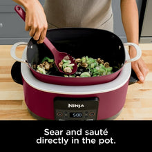 Cherry tarte multi-cooker pot with food and integrated stirring utensil
