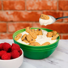 Spoonful of breakfast biscuits over yogurt in a green bowl
