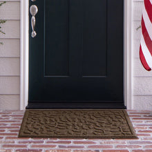 Brown leaf-vine doormat at front door entry, rectangular with dark border