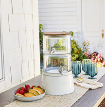 Stacking glass beverage dispenser with acacia wood lid, two metal spigots, white base
