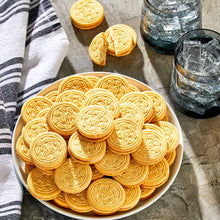 Vanilla sandwich cookies with embossed swirl tops on a plate, close-up