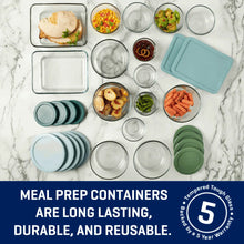 Set of glass meal prep containers with teal and green lids, arranged flat