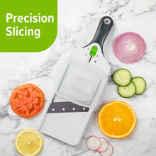 Adjustable mandolin slicer with safety guard and handle, shown with sliced citrus and onions