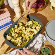 Dark green stoneware baking tray filled with roasted vegetables