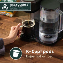 K-Cup pods brewing with carafe and used coffee pod, recyclable label visible