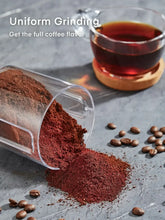Electric coffee burr grinder with glass container filled with dark ground coffee