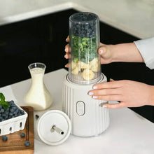 Sand white single serve blender with hands holding Tritan cup