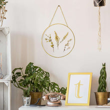 Hanging round glass wall decor with gold rim, chain, and dried pressed floral stems