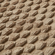 Taupe/brown bubble texture bath rug surface with raised dot-and-foam pattern