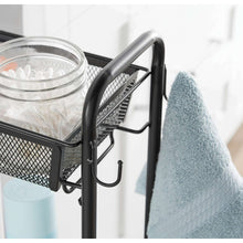 Black bathroom storage cart with curved handle, two wall hooks, and mesh shelf