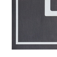 Black indoor laundry runner rug close-up of pebbled texture and light border stripe