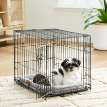 Gray crate mat pet bed inside a metal crate with a dog lying on the cushion.