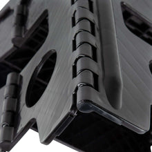 Black plastic step stool leg with textured tread and ridged folding hinge