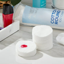 Cotton rounds stack on white surface with red-tinted pad visible.
