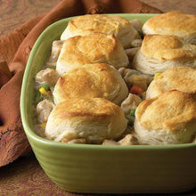 Bowl of poultry gravy with mixed vegetables and golden biscuits