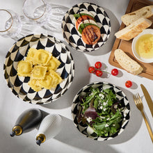 Black-and-white geometric low bowls with food, including salad and pasta