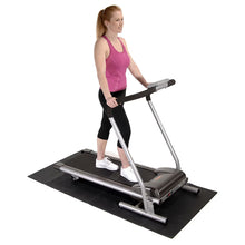 Dark gray foldable exercise mat placed under a fitness machine