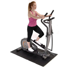 Dark gray folding exercise equipment mat under a fitness machine base