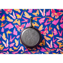 Cast iron skillet with short handle and etched Dolly portrait, on colorful butterfly cloth