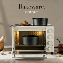 Black nonstick bakeware pot inside a countertop oven, with baking accessories nearby