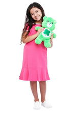 Green plush teddy bear held at the side with clover belly emblem