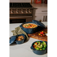 Blue ceramic casserole set with three pots and lids; one dish shown with food