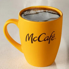 McCafe yellow mug filled with dark coffee