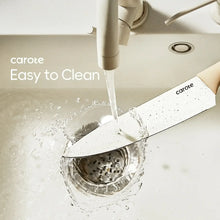 Ceramic kitchen knife rinsed under running water, cream handle and white blade