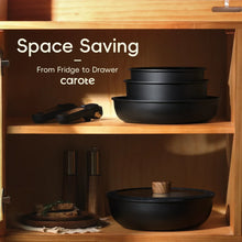Stacked black nonstick cookware bowls in a cabinet shelf for compact storage