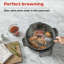 Stainless multi-cooker pot with seared meat and fitted glass lid