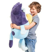 Plush character with purple head and light blue body, yellow muzzle, held in arms