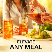 Iced tea brewing bag pitcher and tea glasses with lemon garnish in meal setting