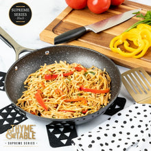 Black speckled non-stick fry pan cooking noodles with vegetables
