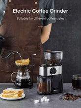 Electric coffee burr grinder with black motor base, clear bean container, and silver top