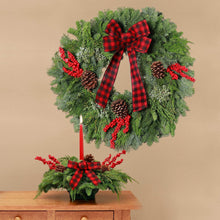 Fresh holly wreath centerpiece with red plaid bow, red berries, and pinecones on stand