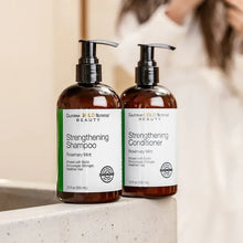 Strengthening shampoo and conditioner bottles with pump dispensers, amber labels.