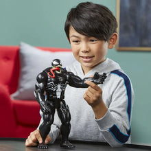 Venom action figure held by a child, black suit with red tongue detail